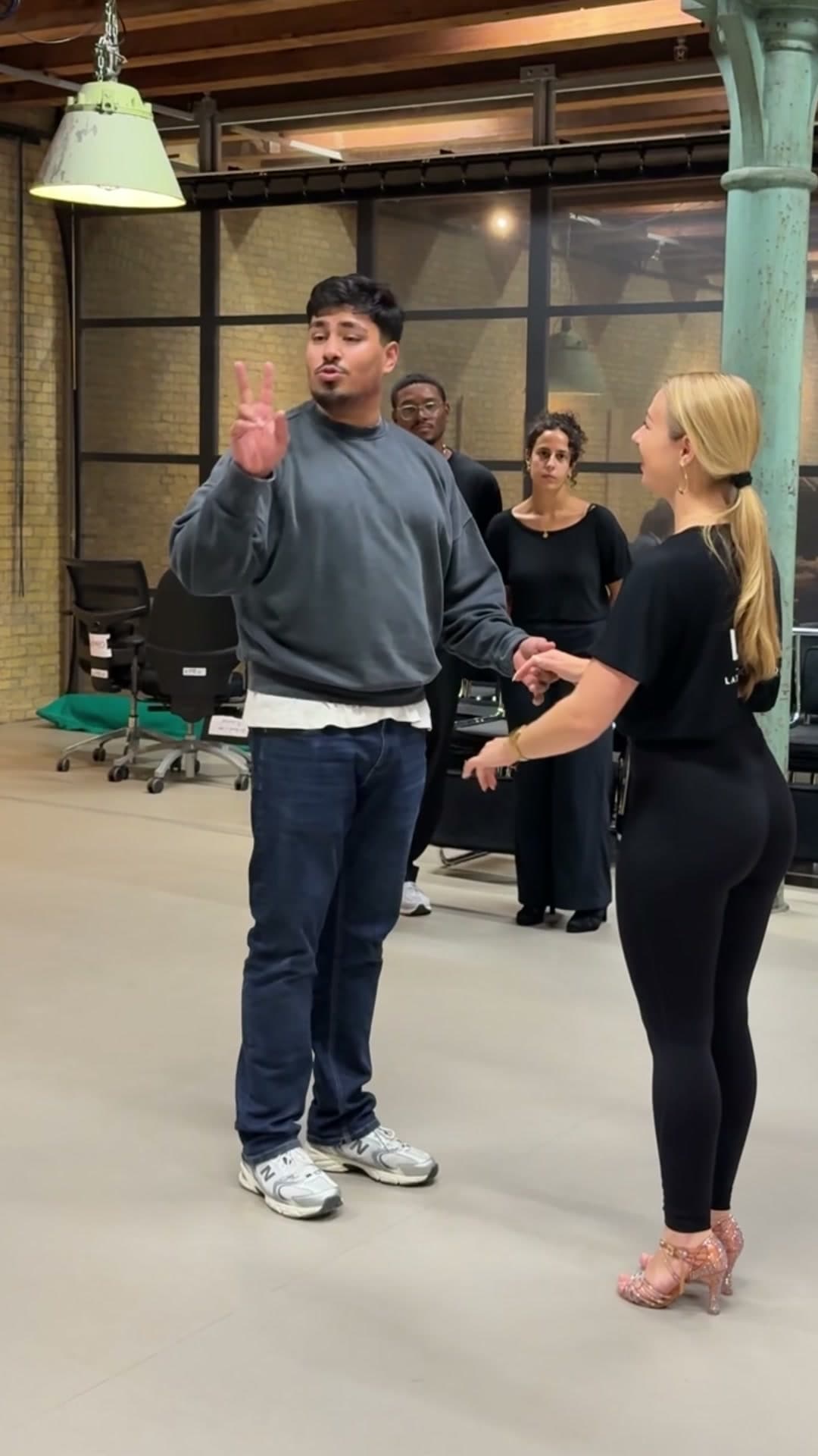 Zubaid legt partnerdans uit aan een groep